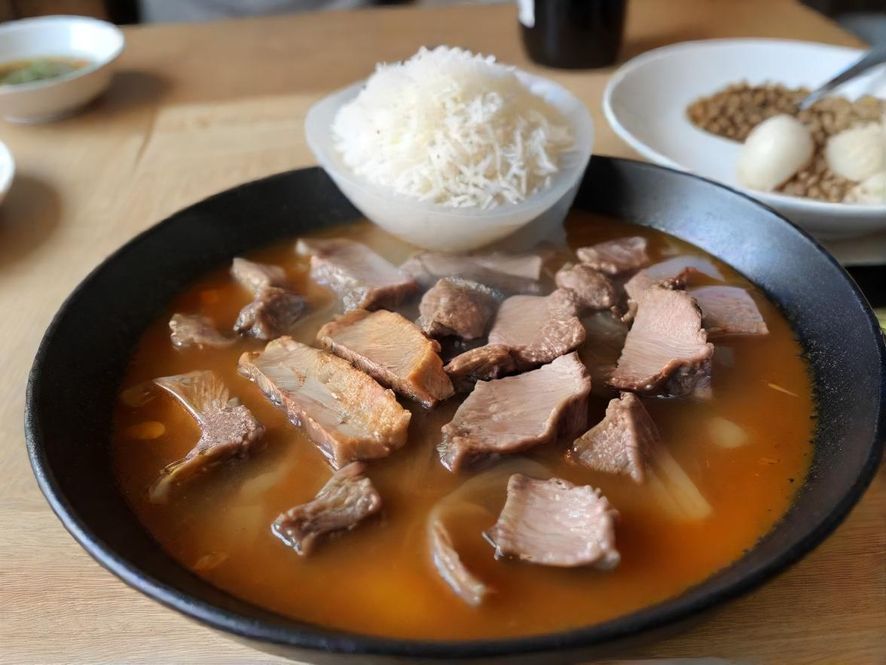 年轻食客在家中笔记本电脑上浏览广东悦来香新网站,脸上洋溢着发现美食的喜悦